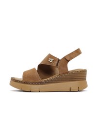 Tan suede wedge sandal with adjustable slingback, open toe, and silver logo accent. Features a textured platform and stitching detail.