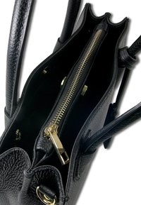 Sac à main en cuir noir avec une texture granuleuse, doté d'une fermeture éclair dorée, de plusieurs compartiments et d'un design structuré.