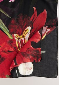 Červený šátek s květinovým vzorem na černém pozadí, zdobený růžemi a orchidejemi, s jemnou, lehkou texturou a zrolovaným okrajem.