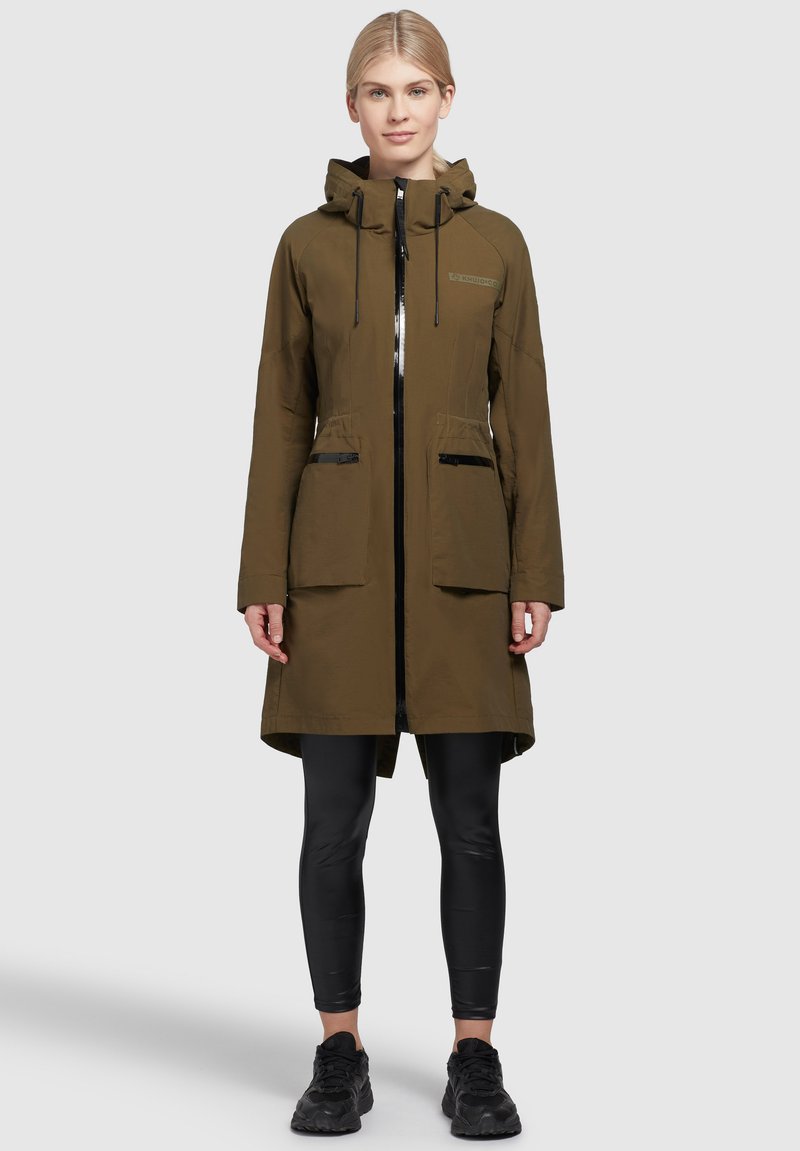 Olivgrüner langer Parka mit Kapuze, Reißverschluss und zwei Fronttaschen. Verfügt über eine glatte Textur und schwarze Reißverschlussakzente.