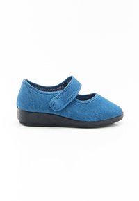 Zapato de tela azul con una correa de velcro, punta redondeada y suela de goma negra. Parte superior texturada con un acabado suave y blando.