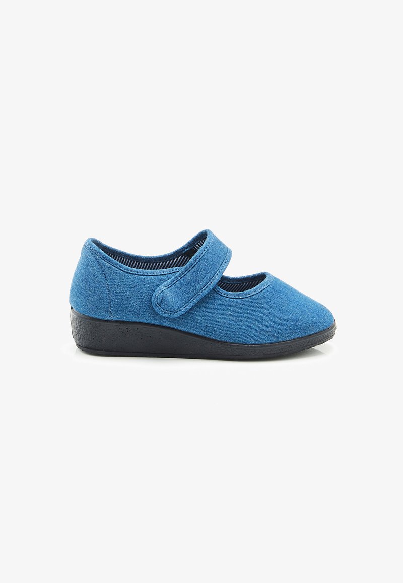 Zapato de tela azul con una correa de velcro, punta redondeada y suela de goma negra. Parte superior texturada con un acabado suave y blando.