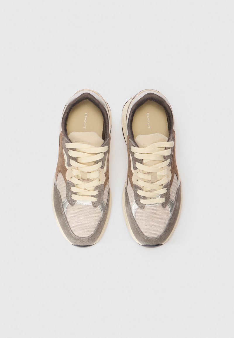 Beige und braune Sportschuhe aus Mesh und Wildleder, mit einer cremefarbenen Sohle und Schnürsenkeln sowie einem reflektierenden silbernen Akzent.