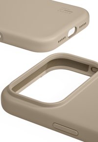 Funda para smartphone de silicona suave beige que muestra recortes en la parte inferior para el altavoz y botones, con un forro interior texturizado para protección y agarre.
