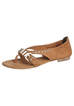 Sandale plate marron avec élastique à la cheville, lanière pour l'orteil, boucle argentée et ornements en clous métalliques sur les brides latérales.