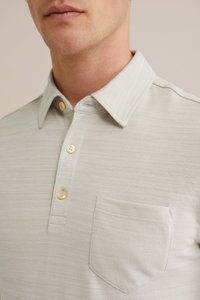 Svetlosivý polo tričko vyrobené z textúrovaného materiálu, s golierom na gombíky, tromi gombíkmi a náprsné vrecko so strojovým okrajom.