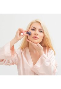 Walcowany w kształcie serca jadeit trzymany przy twarzy, o gładkiej powierzchni. Temat nosi jasnoróżowy satynowy szlafrok z rozszerzanymi rękawami.