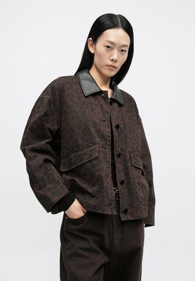 Jachetă maro cu imprimeu leopard, cu guler din piele neagră, prevăzută cu două buzunare frontale și închidere cu nasturi. Material gros și texturat.