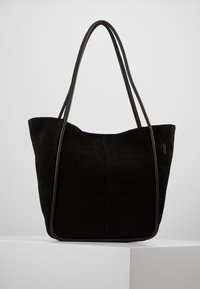 Svart mocka tote-väska med två långa läderhandtag, med en mjuk textur, öppen topp och minimalistisk design.