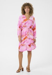 Rosa tie-dye klänning med V-hals, långa ärmar och bälte i midjan. Mjuk tyg med en flödande silhuett och knapppynt.