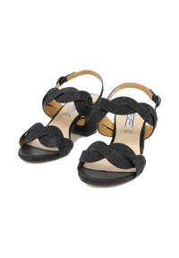 Sandali neri con tacco alto, con un superiore texture glitterato, presentano fasce ondulate e una fibbia alla caviglia. Tacco quadrato a blocco. Soletta di un leggero color nocciola.