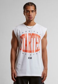 White sleeveless t-shirt featuring a bold orange graphic print with the word "STARTER" and distressed accents. Soft cotton material.