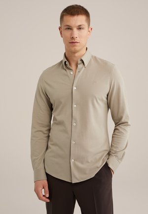 Lange mouwen knoopshirt in lichtbeige, met een gladde textuur, kraag en subtiel logo op de borst.