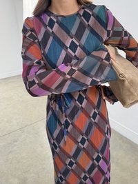 Rochie lungă cu mâneci lungi, multicoloră, cu un model în carouri cu nuanțe de albastru, portocaliu și violet. Fabricată dintr-un material texturat, cu un cordon la talie.