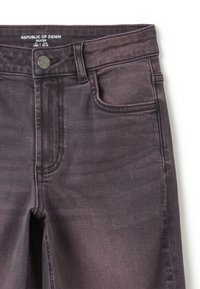 Jeans skater de mezclilla en un color gris oscuro desvanecido, con cierre de botón, cinco bolsillos y una sutil textura horizontal. Marca visible en la cintura.