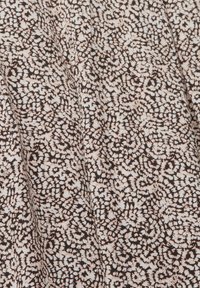 Tessuto nero con un motivo floreale testurizzato e vorticoso in tonalità di rosa e bianco morbide. Il design copre uniformemente l'intera superficie.
