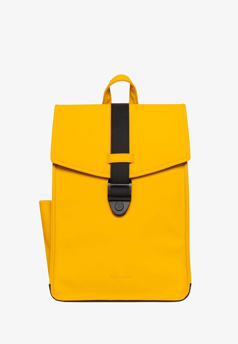 Gelber Rucksack mit Klappenverschluss, schwarzen Riemenakzenten und einer glatten Textur. Verfügt über eine Vorderseite mit Schnalle und einen oberen Griff zum Tragen.
