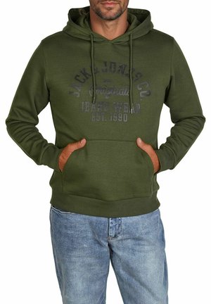 Groene hoodie met een kangaroezak, capuchon met trekkoord en een logo op de voorkant. De stof lijkt zacht met een gladde textuur. Gecombineerd met een blauwe spijkerbroek.