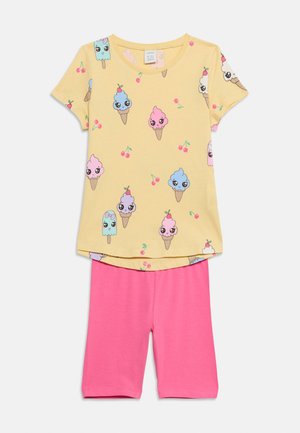 Gul kortærmet top med kawaii is og kirsebærprint, parret med ensfarvede knælange shorts i klar lyserød.