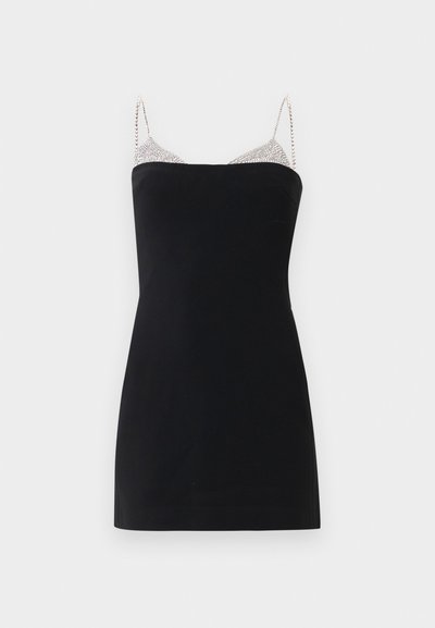 Fekete mini ruha egyenes dekoltárral, vékony ékszeres pántokkal és csillogó részlettel a felső mellkason, sima fehér háttér előtt.