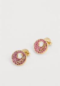 Guldcirkulära örhängen prydda med rosa kristaller; har en utskuren mitt och "GUESS"-logotyp, med en polerad finish och säker fäste.