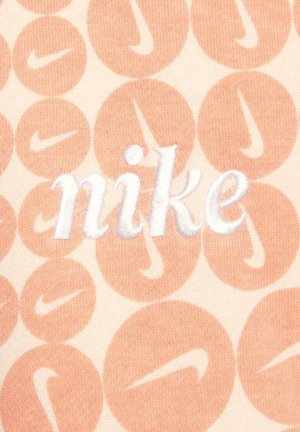 Helles beige Stoffmuster mit einem sich wiederholenden, hellorangefarbenen, kreisförmigen Muster, das das Nike-Logo zeigt. Das Wort "nike" ist in weißem Faden gestickt.