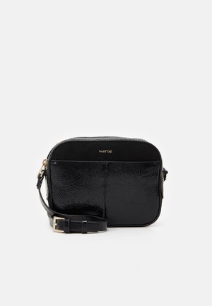 Black crossbody bag with a glossy, textured finish, rectangular shape, and adjustable strap. Features a gold logo accent on the front.