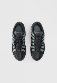 Black and teal Nike sneakers featuring mesh and synthetic materials, with six adjustable laces, padded collar, and logo accents.