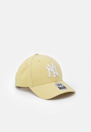 Gorra de béisbol de color amarillo claro con el logo "NY" blanco bordado en la parte delantera y una visera curvada con una pegatina de la marca en blanco y negro.