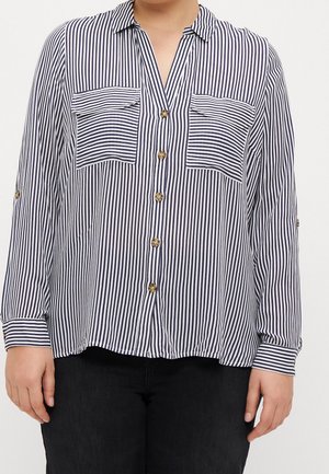 Long-sleeve shirt featuring a navy and white vertical stripe pattern, two chest pockets, button closure, and a relaxed fit.