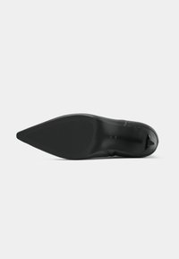 Scarpa nera con tacco alto, punta appuntita, texture liscia e suola nera solida. Presenta dettagli minimi e un design elegante.