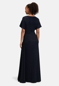 Maxikleid in dunklem Marineblau, mit lockerer Passform, kurzen Ärmeln, gerippter Textur und einem discreet verborgenen Reißverschluss im Rücken. Geschmeidiger, fließender Stoff.