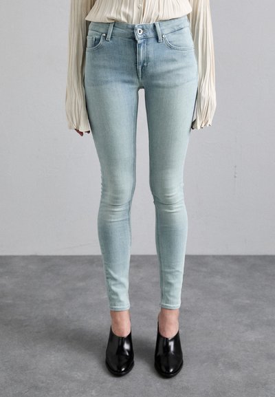 Lyse blå smale jeans med en falmet vask, som har en frontlukking med knapp, beltehemper og en slank passform, sammen med svarte hæler.
