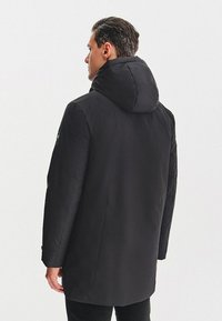 Czarny ocieplany płaszcz z kapturem, posiadający prosty krój, gładki materiał i boczne kieszenie. Minimalistyczny design bez widocznych wzorów czy akcentów.