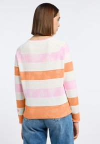 Gestreepte trui in lichtbeige met roze, oranje en witte horizontale strepen. Heeft een ronde halslijn en een geribbelde onderrand.