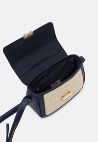 Borsa a tracolla blu navy con pannello in paglia intrecciata, chiusura in metallo dorato, tasca interna con zip, texture in pelle liscia, forma strutturata.