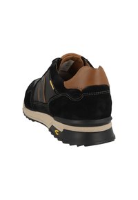 Sneaker nera in suede con accenti in pelle marrone, pannelli laterali testurizzati e suola in gomma beige. Presenta dettagli gialli vicino al tallone.