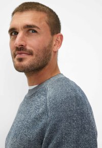 Grå-blå strikket sweater med tekstureret stof, runde halsudskæringer og ribbet krave. Har subtile farvevariationer og en afslappet pasform.