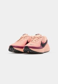 Lightweight running shoes featuring a pink mesh upper, black Nike swoosh, gradient purple accents, and textured black outsole.