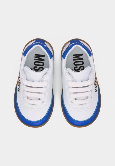 Λευκά παιδικά αθλητικά παπούτσια με μπλε περίγραμμα, καφέ σόλες, λευκά κορδόνια και λογότυπο "Moschino" στις πλευρές και στις ταμπελίτσες στη φτέρνα, απεικονιζόμενα από πάνω.