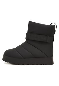 Bota aislante negra con parte superior acolchada, equipada con costuras horizontales, una amplia correa de tela y una suela gruesa y texturizada.