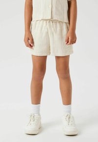 Ensemble en deux pièces en mélange de coton couleur crème, composé d'un haut à manches courtes et d'un short à taille élastique, avec une coupe décontractée.