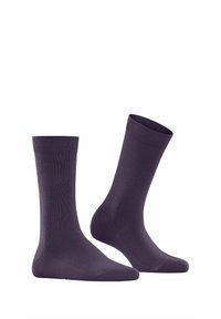 Une paire de chaussettes unies violettes foncées de longueur moyenne sur fond blanc.