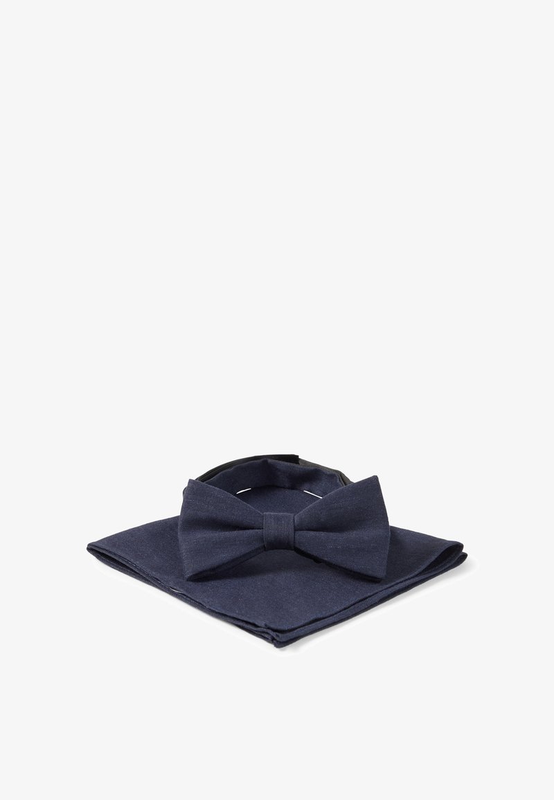 Papillon blu navy e fazzoletto da taschino abbinato ordinatamente disposti su uno sfondo bianco.