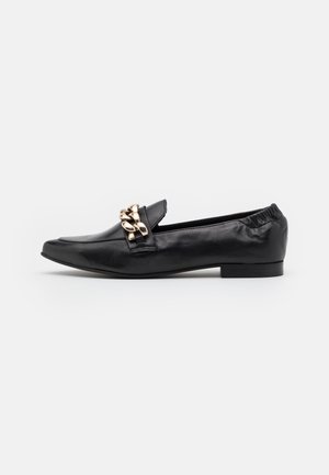 Mocassin en cuir noir à bout pointu, orné d'une chaîne décorative dorée sur le dessus et doté d'un talon plat. Texture douce, design sans lacets.
