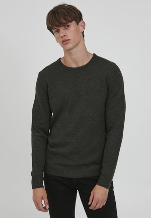 Dunkelgrüner Strickpullover mit Rundhalsausschnitt, langen Ärmeln, gerippten Bündchen und Saum, der eine strukturierte Oberfläche und eine figurbetonte Silhouette aufweist.