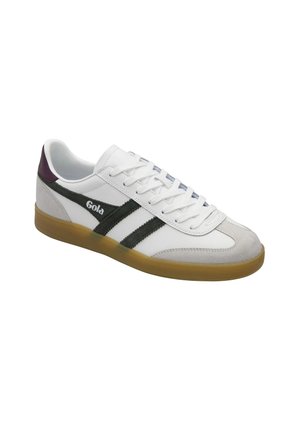 Witte lage sneaker met zwarte zijstrepen, beige neuskap, rubberen zool en een paarse hieltab, met de merknaam Gola aan de zijkant.