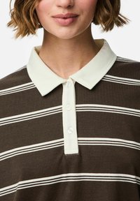 Bruin gestreept polo shirt met een lichtgekleurde kraag, voorzien van knoopsluiting en een zachte stoftextuur. Versterkt door horizontale witte strepen.