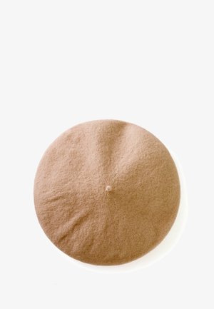 Světle hnědý filcový baret s kulatým tvarem a malým knoflíkem na vrcholu. Povrchová textura se zdá být měkká a mírně texturovaná.