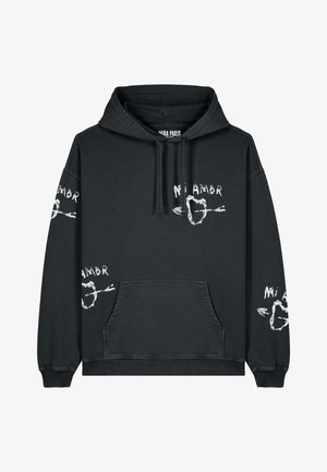 Svart hoodie i bomull, med en framficka. Texten "Mi Amor" i vitt på både ärmarna och i fronten, med hjärt- och pilgrafik som accentuerar.